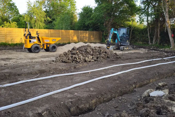 Drainage pipe routes and groundwork across a clay-soil site